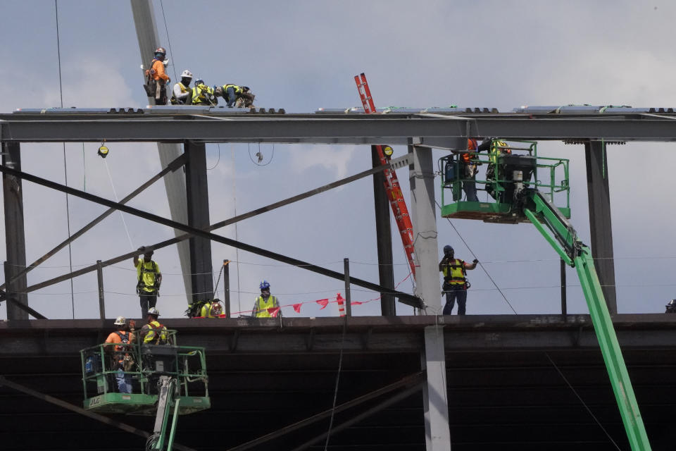 Construction personnel work on Carolina Panthers' state-of-the-art team headquarters and practice facility Tuesday, Aug. 24, 2021, in Rock Hill, S.C. "The Rock" will host all of the team's offices and training/locker room facilities, along with three outdoor grass practice fields, one indoor artificial field and another outdoor artificial field that is part of a 5,000-seat multipurpose stadium that can also be used to host high school football and soccer games, concerts, car shows and much more. (AP Photo/Chris Carlson)