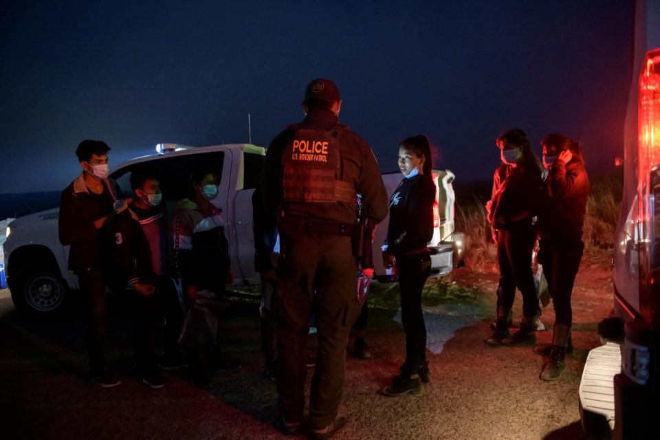 In a photo taken on March 27, 2021, unaccompanied children stand at a makeshift processing checkpoint with border patrol agents in the border city of Roma. / Credit: ED JONES/AFP via Getty Images