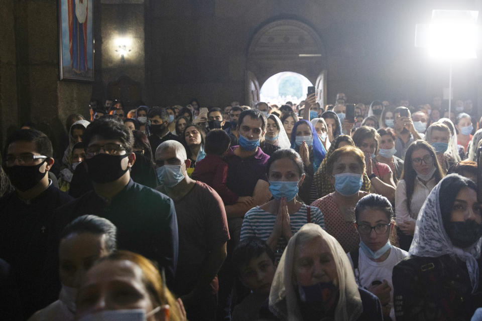 People attend a nationwide prayer for peace lead by Catholicos Karekin II in the Saint Gayane Church in Yerevan, Armenia, Saturday, Oct. 3, 2020. Armenia and Azerbaijan say heavy fighting is continuing in their conflict over the separatist territory of Nagorno-Karabakh and Azerbaijan's president said late Saturday that his troops had taken a village. (Grigor Yepremyan/PAN Photo via AP)