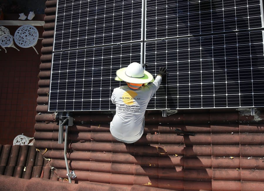 Andres Hernandez, from the Goldin Solar company, installs a solar panel system on the roof of a home on Jan. 23, 2018, in Palmetto Bay, Florida. (Photo by Joe Raedle/Getty Images)