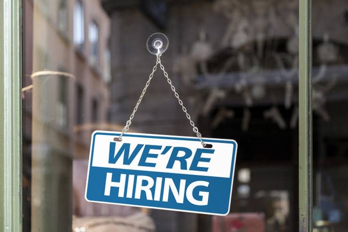 "We're Hiring" sign in a restaurant window