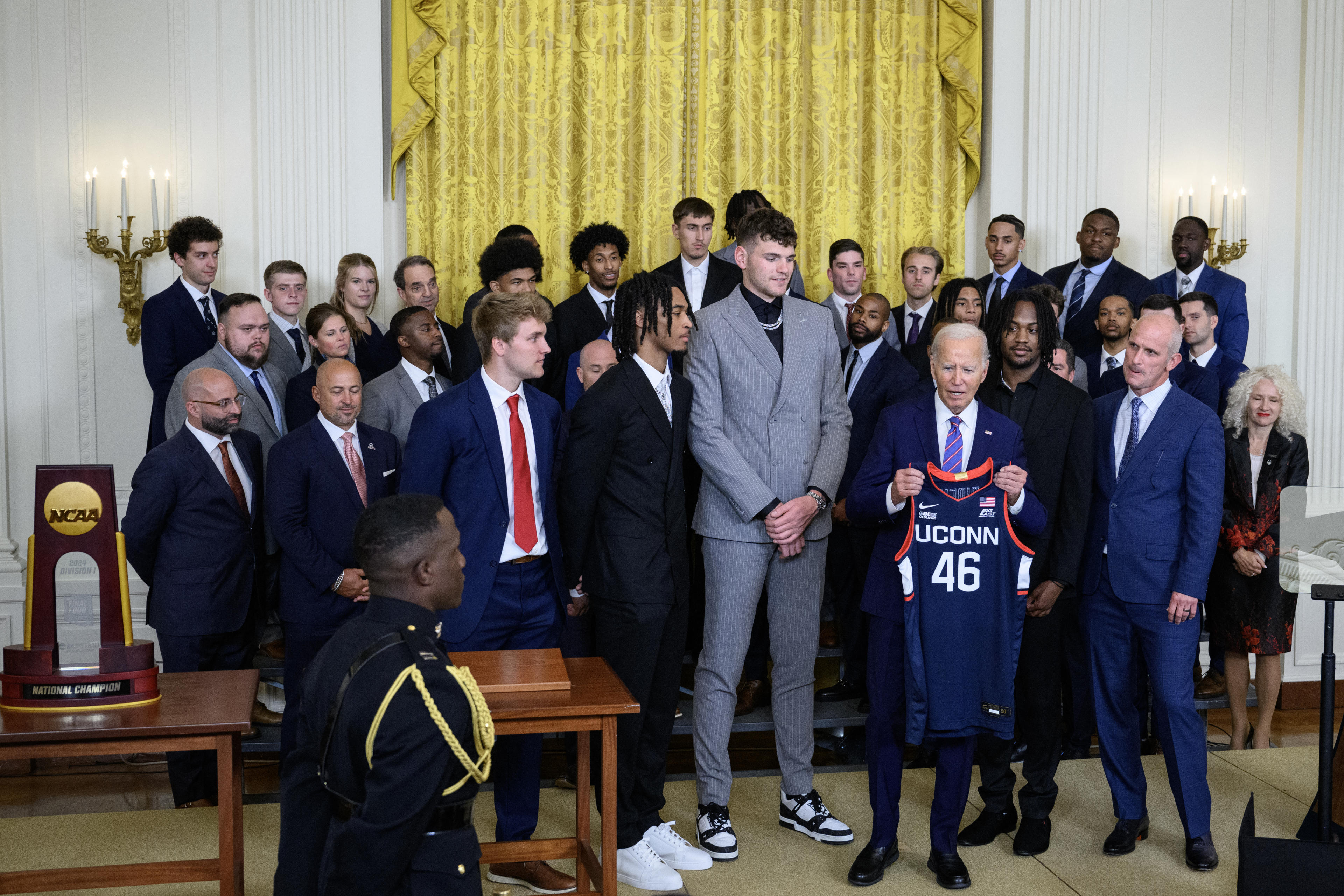 US President Joe Biden holds up a jersey given to him during an event to celebrate the University of Connecticut men's basketball team for their 2023-2024 championship season, in the East Room of the White House on September 10, 2024, in Washington, DC. (Photo by Drew ANGERER / AFP) (Photo by DREW ANGERER/AFP via Getty Images)