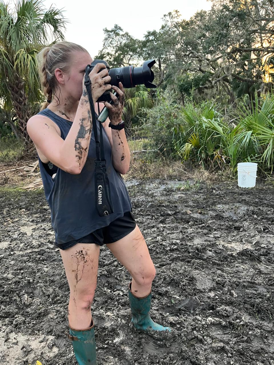 Tallahassee Democrat photojournalist Alicia Devine, who is covered in mud and Suwannee River water, takes photos while on assignment in Suwannee, Fla. on Thursday, Aug. 31, 2023.