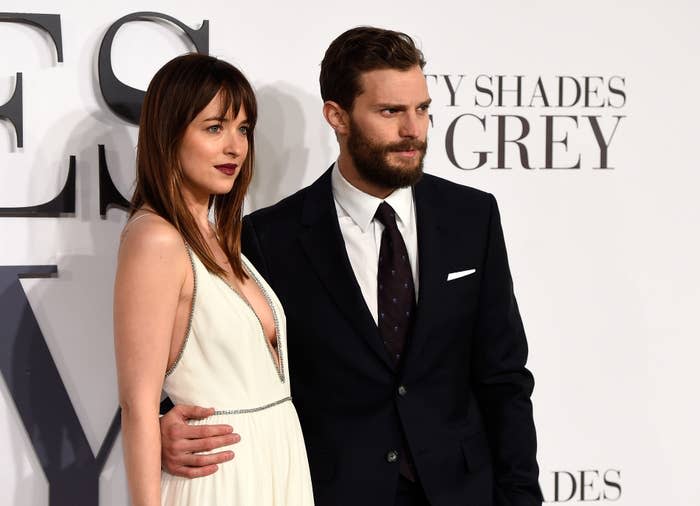 Dakota Johnson in a gown and Jamie Dornan in a dark suit pose together at the "Fifty Shades of Grey" premiere