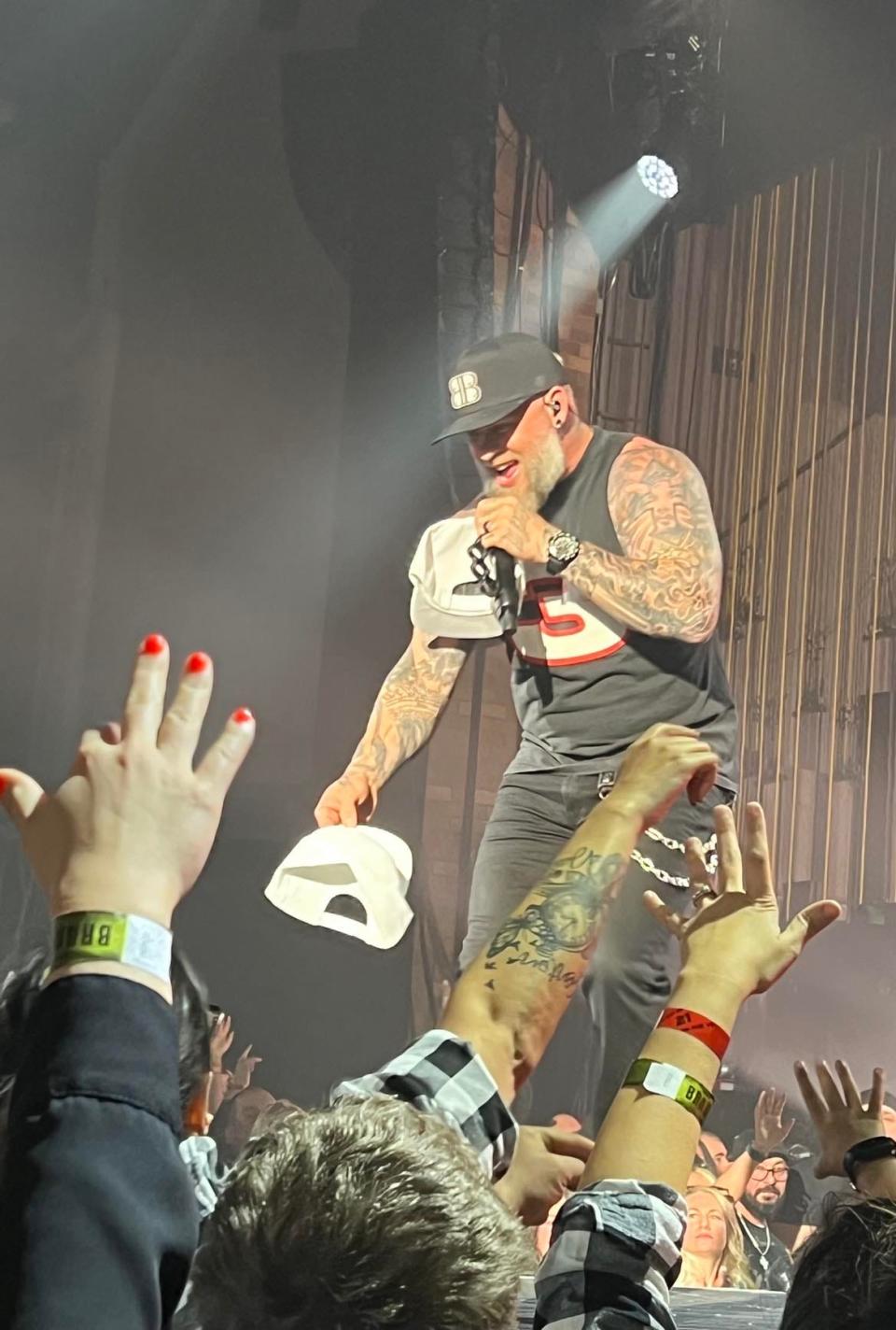 Country music artist Brantley Gilbert hands out hats to fans at Thursday night's concert at the Canton Memorial Civic Center.