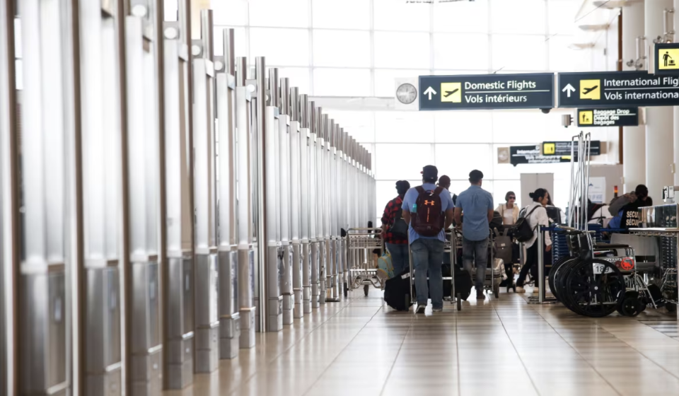 Passengers and signage at the Winnipeg airport. (John Woods/The Canadian Press)