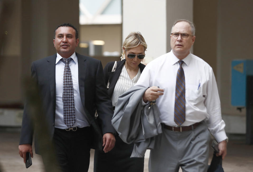 Attorneys for the defendants Lawrence Hashish, left, David Frankel, right, and paralegal Juliana Marulanda, center, walk into the Broward County Jail on Monday, Aug. 26, 2019, in Fort Lauderdale, Fla. Three people, including two nurses, are surrendering following charges in the case of a Florida nursing home where 12 patients died after losing power went out amid sweltering heat following Hurricane Irma in 2017. (AP Photo/Brynn Anderson)