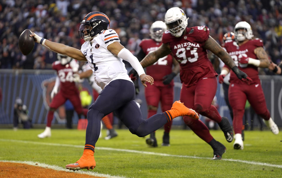 Chicago Bears quarterback Justin Fields scores past Arizona Cardinals defensive end Jonathan Ledbetter during the first half of an NFL football game Sunday, Dec. 24, 2023, in Chicago. (AP Photo/Erin Hooley)