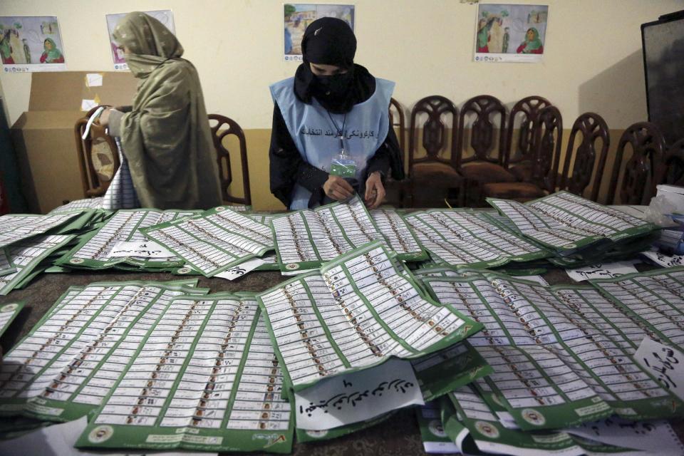 An Afghan election worker checks ballots at a polling station in Jalalabad, east of Kabul, Afghanistan, Saturday, April 5, 2014. (AP Photo/Rahmat Gul)