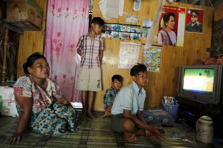 Kyaw Khine Soe (R), 16, sits inside his home with his family outside Yangon, Myanmar February 17, 2016. REUTERS/Soe Zeya Tun