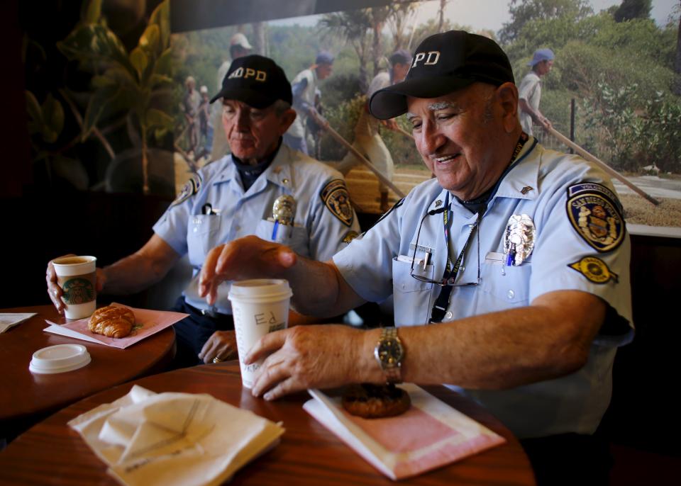 Eighty-eight year-old Ed Robles (R), a member of the Retired Senior Volunteer Patrol grabs a coffee with partner Richard Engel in San Diego, California, United States February 24, 2015. (REUTERS/Mike Blake)