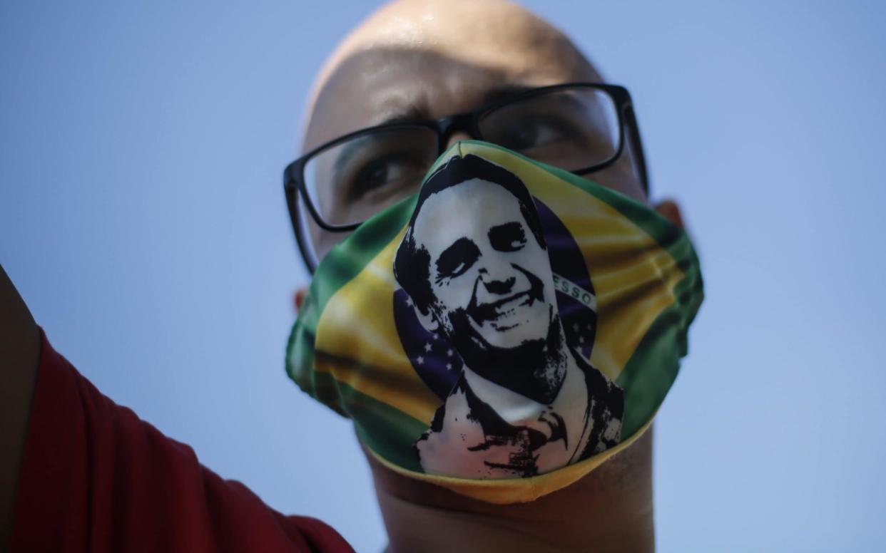  A supporter of Jair Bolsonaro wears a face mask with the president's image - Getty Images