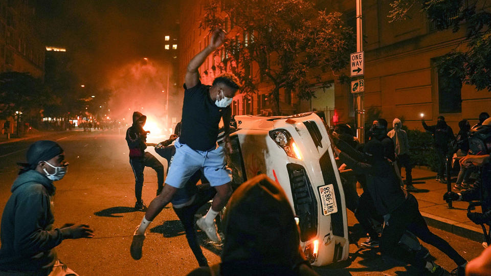 Demonstrators vandalize a car as they protest the death of George Floyd, Sunday, May 31, 2020, near the White House in Washington. Floyd died after being restrained by Minneapolis police officers. (Evan Vucci/AP)