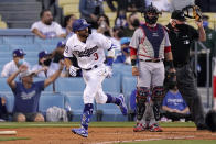 Los Angeles Dodgers' Chris Taylor, left, runs to first as he hits a three-run home run as Washington Nationals catcher Yan Gomes watches during the second inning of a baseball game Saturday, April 10, 2021, in Los Angeles. (AP Photo/Mark J. Terrill)