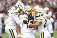 Missouri quarterback Brady Cook (12) celebrates a touchdown with tight end Ryan Hoerstkamp (84) and running back Cody Schrader (20) during the first half of an NCAA college football game against South Carolina, Saturday, Oct. 29, 2022,in Columbia, S.C. (AP Photo/Artie Walker Jr.)