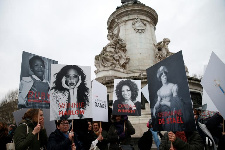 Demonstrators hold placards depicting famous women on Place de la Republique in Paris on March 8, 2018 during a demonstration to mark International Women's Day