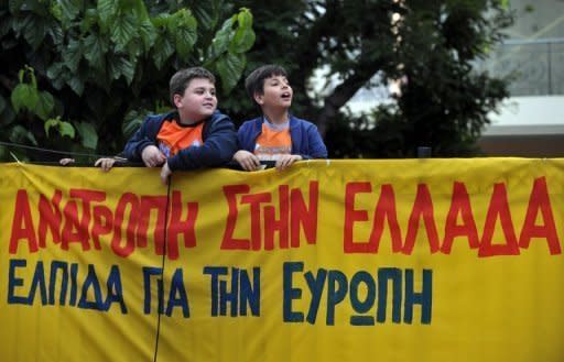 Greek children watch the Syriza party leader (unseen) make a speech in Athens in May 2012. No debt repayments, higher salaries and freedom from EU-IMF tutelage: Greece under the radical leftists, who are poised to win a June 17 election, seems a world removed from its current recession nightmare