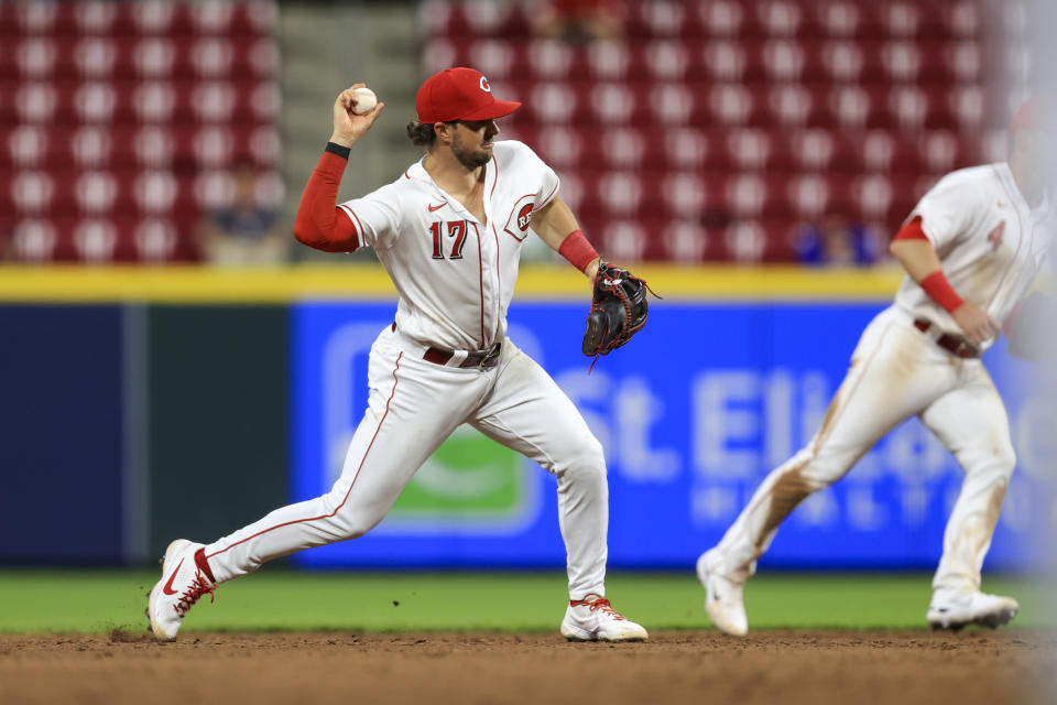 Cincinnati Reds' Kyle Farmer fields the ball and throws out Milwaukee Brewers' Tyrone Taylor at first base during the ninth inning of a baseball game in Cincinnati, Monday, May 9, 2022. (AP Photo/Aaron Doster)