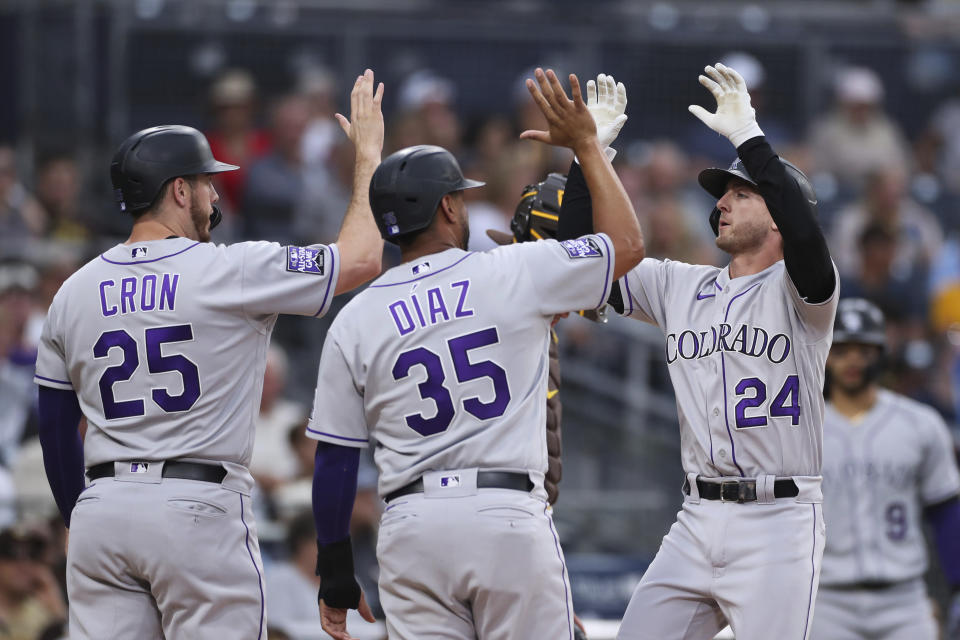 Colorado Rockies' Ryan McMahon, right, celebrates with Elias Diaz (35) and C.J. Cron (25) after hitting a grand slam against the San Diego Padres during the first inning of a baseball game Friday, July 30, 2021, in San Diego. (AP Photo/Derrick Tuskan)