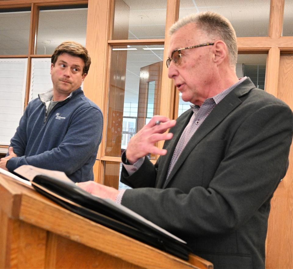 Production manager Chris Bauer looks on while PSI Michigan-Indiana vice president Mark Titus apologizes for broken promises on the Alumni Stadium construction  project.