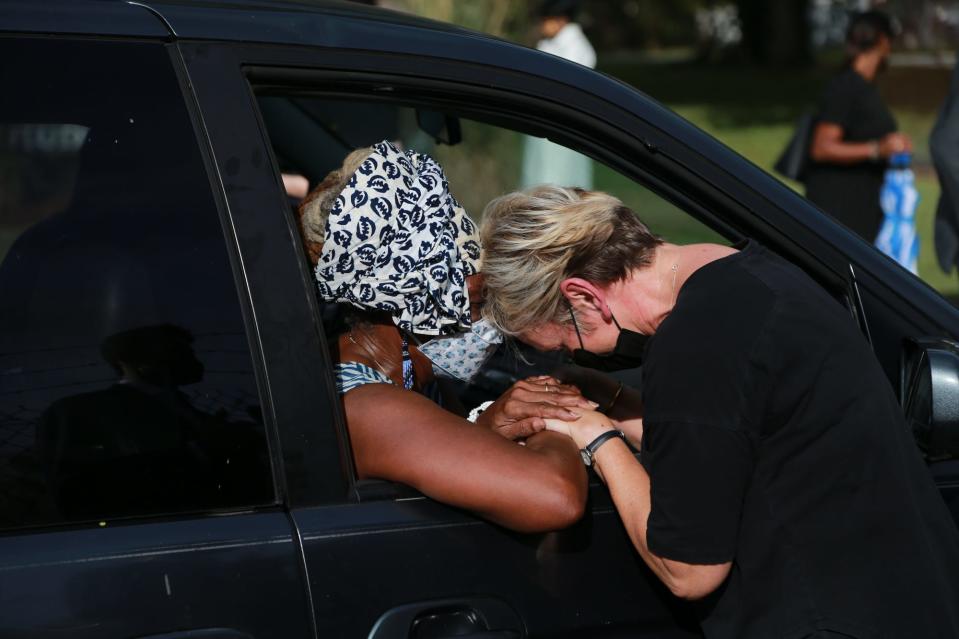 Energy Secretary Jennifer Granholm, right, shares a prayer with Mildred McClain, executive director of the Harambee House, following a visit to the Hudson Hill neighborhood.