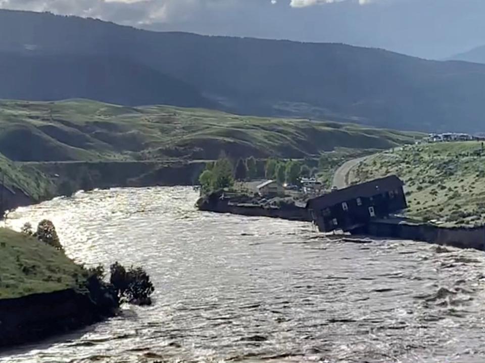 A house falls into the Yellowstone river due to flooding in Gardiner, Montana, U.S., June 13, 2022 in this screen grab obtained from a social media video (Angie Lilly via REUTERS)