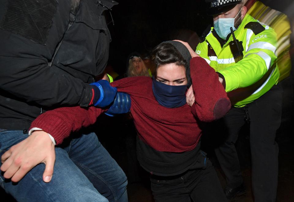 Police officers scuffle with people gathering at a band-stand where a planned vigil in honour of murder victim Sarah Everard was cancelled after police outlawed it due to Covid-19 restrictions, on Clapham Common, south London on March 13, 2021, - The police officer charged with murdering young Londoner, Sarah Everard, who disappeared while walking home from a friend's house, appeared in court on March 13, 2021, as organisers cancelled a vigil in her honour due to coronavirus restrictions. (Photo by JUSTIN TALLIS / AFP) (Photo by JUSTIN TALLIS/AFP via Getty Images)