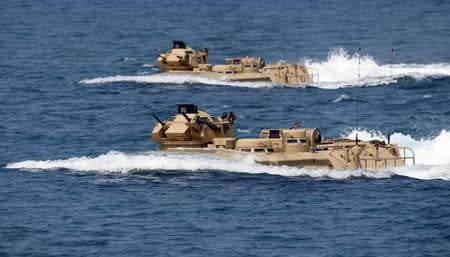 U.S. military forces aboard Amphibious Assault Vehicles (AAV) manuevre on South China Sea near the shore of San Antonio, Zambales during the annual "Balikatan" (shoulder-to-shoulder) war games with Filipino soldiers in northern Philippines April 21, 2015. REUTERS/Erik De Castro