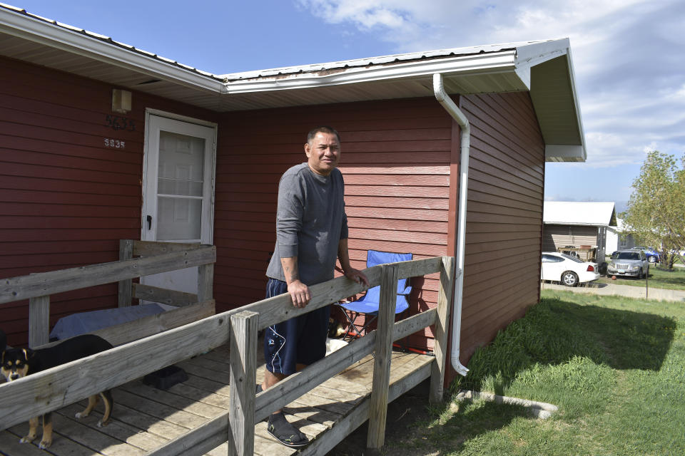 In this Thursday, May 20, 2021, photo, Donald Whitelightning Jr. stands outside his house on the Standing Rock Sioux Reservation in Cannon Ball, N.D. Lower on the Missouri, the Standing Rock Reservation grapples with high energy costs. There's no oil worth extracting, no gas or coal. The biggest employer other than the government is the Prairie Knights Casino, where revenue plummeted during the pandemic. "There's nothing here. No jobs. Nothing," said Whitelightning, Jr. (AP Photo/Matthew Brown)