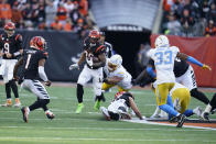 Cincinnati Bengals' Joe Mixon (28) runs out of the tackle of Los Angeles Chargers' Breiden Fehoko (96) during the second half of an NFL football game, Sunday, Dec. 5, 2021, in Cincinnati. (AP Photo/Michael Conroy)