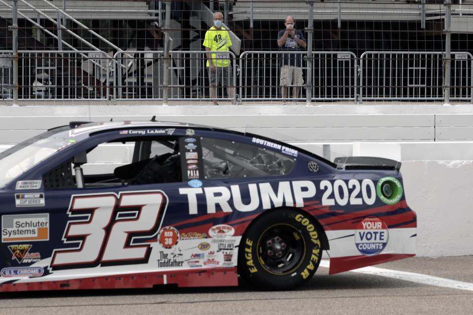 Fans view the car of NASCAR driver Corey LaJoie (32), bearing wording to support the re-election bid of President Donald Trump, before a NASCAR Cup Series auto race, Sunday, Aug. 2, 2020, at the New Hampshire Motor Speedway in Loudon, N.H. (AP Photo/Charles Krupa)