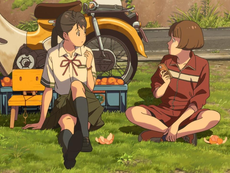 suzume and chika in makoto shinkai's suzume. they're both teenage girls, sitting together on the grass and eating oranges together. suzume is wearing a school uniform with a green skirt and red ribbon around her neck, while chika is wearing a red sweat suit with shorts. behind them are several open crates of oranges and chika's weathered yellow moped, as well as suzume's three legged chair with a key looped around its back rest