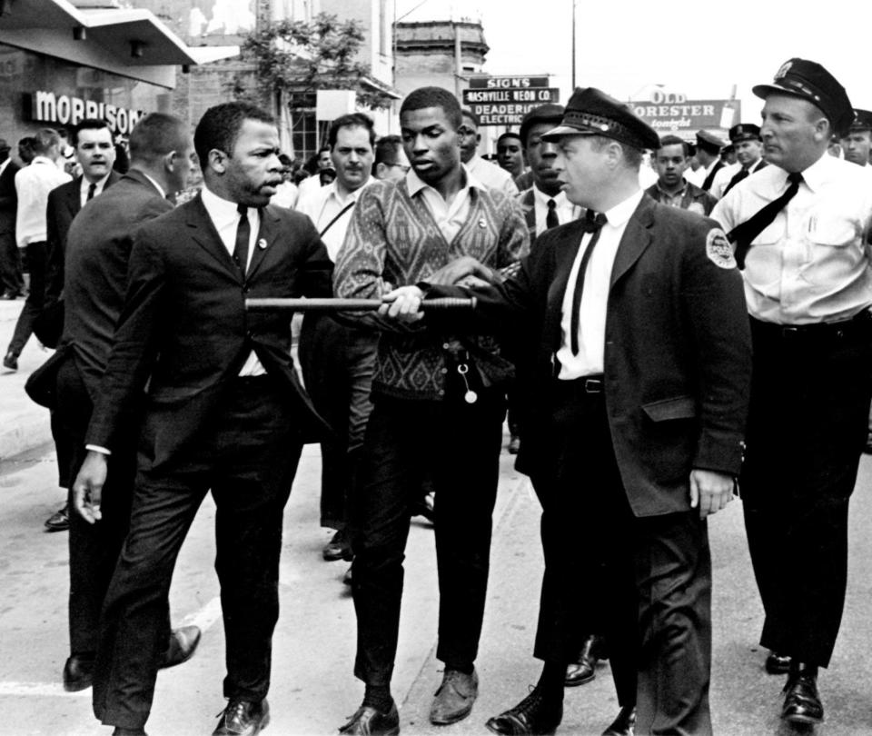 A Metro police officer points his stick at John Lewis (left), one of the leaders of the civil rights demonstrators at Morrison's Cafeteria, =in Nashville, Tenn. on April 29, 1964.