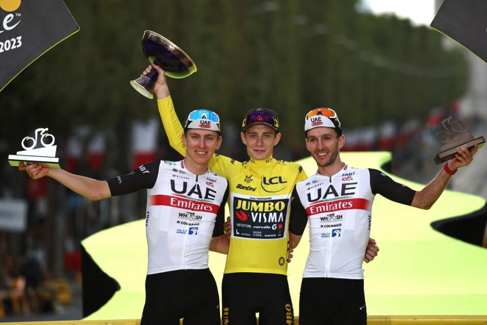 TOPSHOT  JumboVismas Danish rider Jonas Vingegaard wearing the overall leaders yellow jersey C UAE Team Emirates Slovenian rider Tadej Pogacar  in overall second place L and UAE Team Emirates British rider Adam Yates in overall third place R celebrate on the podium after the 21st and final stage of the 110th edition of the Tour de France cycling race 115 km between SaintQuentinenYvelines and the ChampsElysees in Paris on July 23 2023 Photo by AnneChristine POUJOULAT  AFP Photo by ANNECHRISTINE POUJOULATAFP via Getty Images