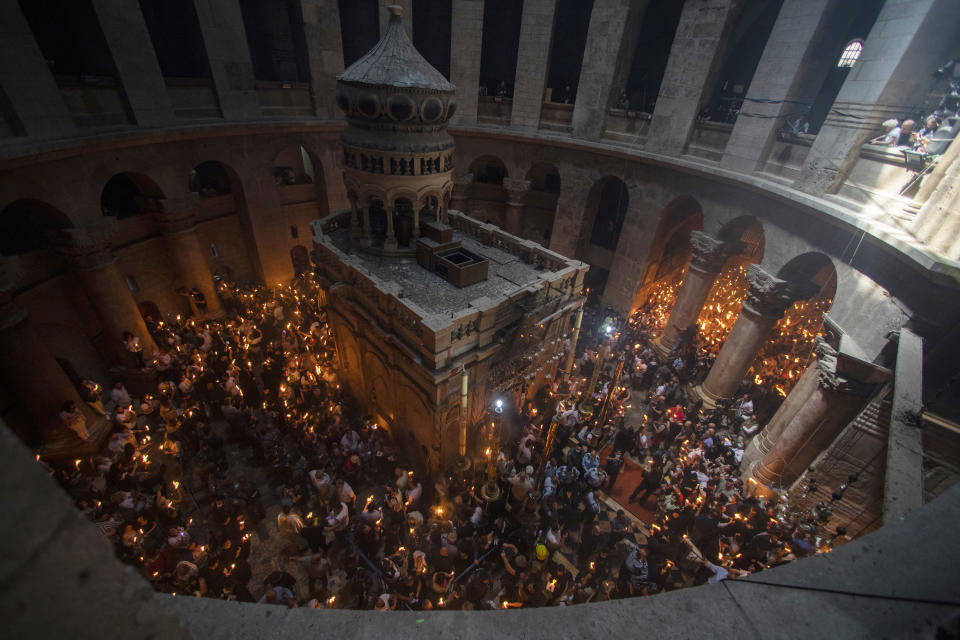 Christian pilgrims hold candles as they gather during the ceremony of the Holy Fire at Church of the Holy Sepulchre, where many Christians believe Jesus was crucified, buried and rose from the dead, in the Old City of Jerusalem, Saturday, May 1, 2021. Hundreds of Christian worshippers took use of Israel's easing of coronavirus restrictions Saturday and packed a Jerusalem church revered as the site of Jesus' crucifixion and resurrection for an ancient fire ceremony ahead of Orthodox Easter. (AP Photo/Ariel Schalit)