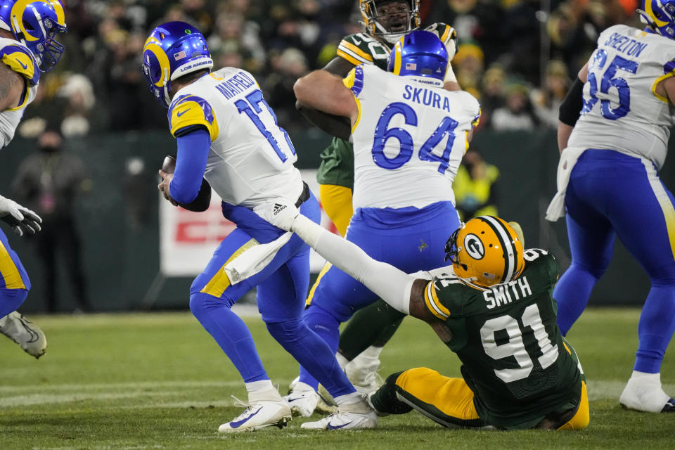 Green Bay Packers linebacker Preston Smith (91) sacks Los angles Rams quarterback Baker Mayfield (17) in the first half of an NFL football game in Green Bay, Wis. Monday, Dec. 19, 2022. (AP Photo/Morry Gash)