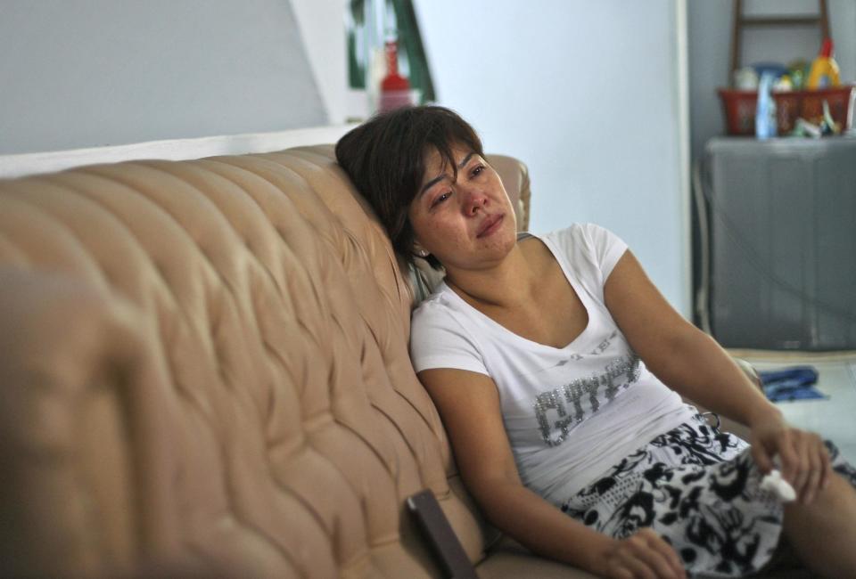 Yenny, hermana de Sugianto Lo, pasajera del avión malayo desaparecido, llora al ver por televisión el anuncio de que se da por sentado que el aparato cayó en el Pacífico y que no hay sobrevivientes. Foto del 25 de marzo del 2014 tomada en Medan, Indonesia. (AP Photo/Binsar Bakkara)