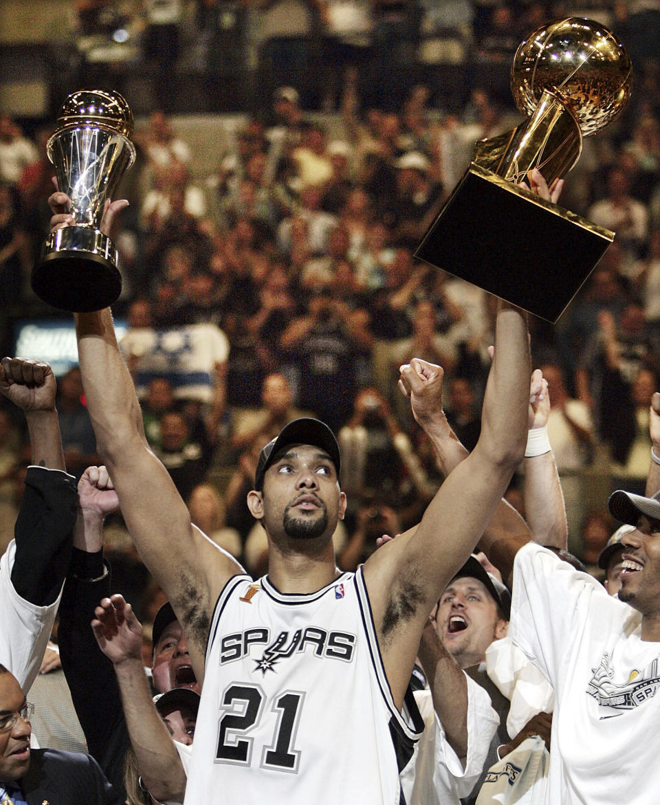 FILE - In this June 23, 2005, file photo, San Antonio Spurs' Tim Duncan (21) holds his MVP trophy, left, and the NBA basketball Championship trophy, right, after San Antonio won 81-74 to winGame 7 of the NBA finals in San Antonio. Joining Kobe Bryant as first-time finalists for the Basketball Hall of Fame are: 15-time All-Star Duncan, fellow 15-time All-Star Kevin Garnett and 10-time WNBA All-Star and four-time Olympic gold medalist Tamika Catchings. (AP Photo/Eric Gay, File)