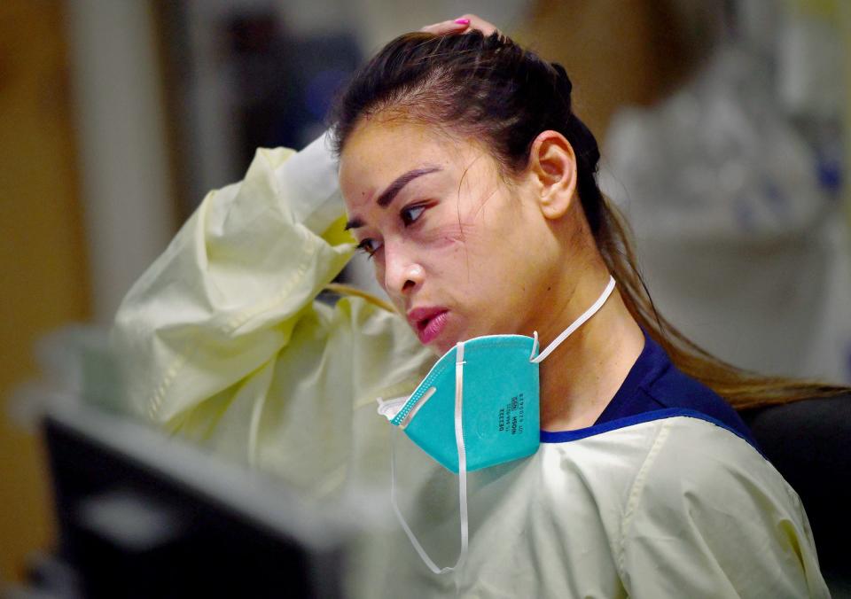 Travel nurse Thu Nguyen catches her breath inside the ICU unit at Providence Holy Cross Medical Center in Los Angeles on Tuesday, Feb. 9, 2021. Nurses are required to wear PPE for hours at a time while working with patients, sometimes causing bruises or scars around their eyes and nose.