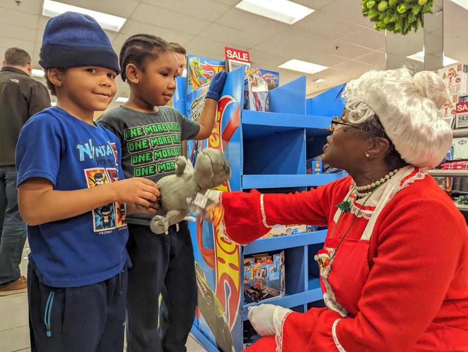 Mrs. Claus visits with Ross Elementary students who were on a shopping spree sponsored by Advisors Excel on Wednesday afternoon at Kohl's.