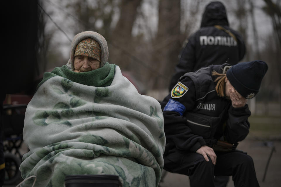 FILE - A Ukrainian police officer is overwhelmed by emotion after comforting people evacuated from Irpin on the outskirts of Kyiv, Ukraine, Saturday, March 26, 2022. With its aspirations for a quick victory dashed by a stiff Ukrainian resistance, Russia has increasingly focused on grinding down Ukraine’s military in the east in the hope of forcing Kyiv into surrendering part of the country’s eastern territory to end the war. If Russia succeeds in encircling and destroying the Ukrainian forces in Donbas, the country’s industrial heartland, it could try to dictate its terms to Kyiv -- and possibly attempt to split the country in two. (AP Photo/Vadim Ghirda)