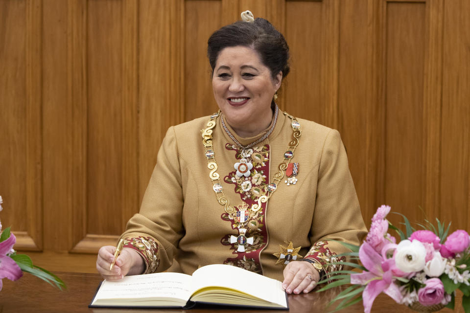 New Zealand Governor-General Dame Cindy Kiro signs a visitor's book after her official swearing-in ceremony at Parliament in Wellington, New Zealand, Thursday, Oct. 21, 2021. Kiro, 63, said her mixed Maori and British heritage helped give her a good understanding of New Zealand history and the Treaty of Waitangi, the founding document signed by Maori and British. (Mark Mitchell/New Zealand Herald via AP)