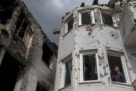 A man stands inside a destroyed house in Kumanovo, Macedonia, May 11, 2015. REUTERS/Marko Djurica