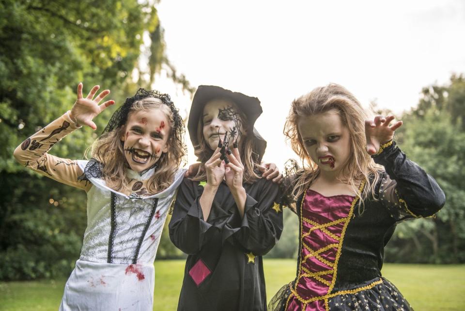 three children dressed in costume for halloween night