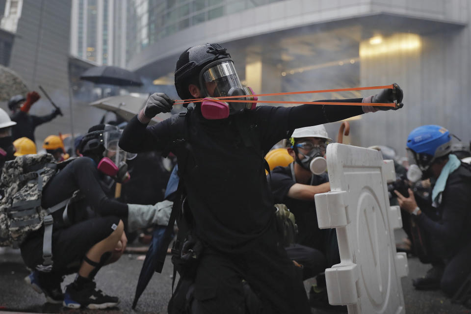 A protester fires a sling shot toward police lines during a protest in Hong Kong, Sunday, Aug. 25, 2019. Police were skirmishing with protesters in Hong Kong for a second straight day on Sunday following a pro-democracy march in an outlying district. (AP Photo/Kin Cheung)