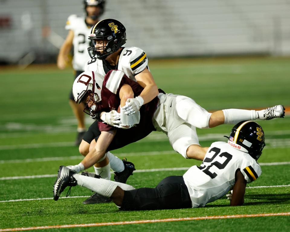 Southeast Polk's Draven Woods (9) tackles Dowling Catholic's Will Leifker at Valley Stadium on Friday, Aug. 26, 2022.