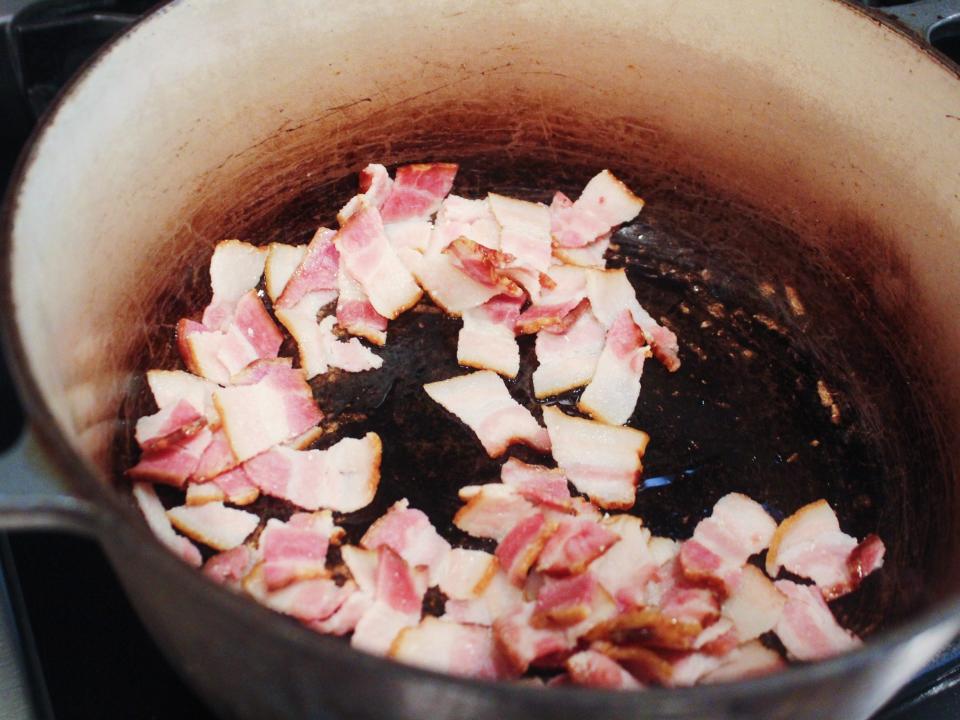 bacon sautéing in pan on stove