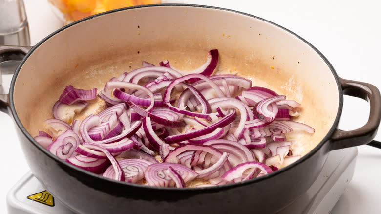 sliced red onions in pan