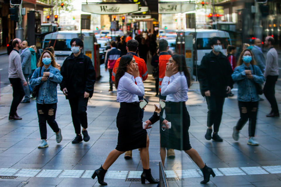 People wearing masks shown walking along a popular shopping strip in Sydney CBD.