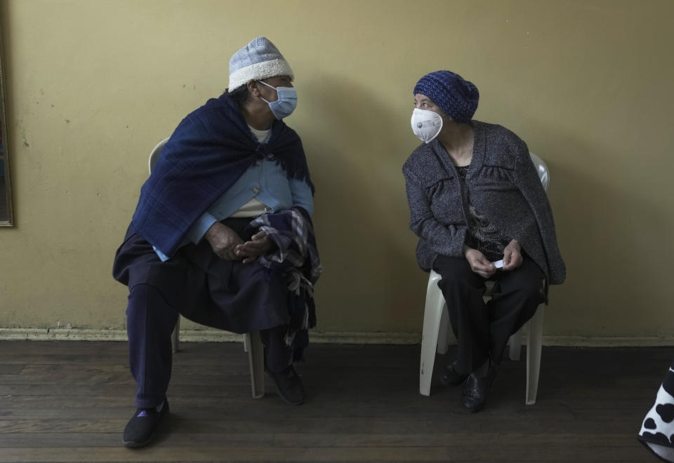 Women visit with eachother as they wait for a shot of the COVID-19 vaccine in Pillaro, Ecuador, Thursday, July 8, 2021. (AP Photo/Dolores Ochoa)